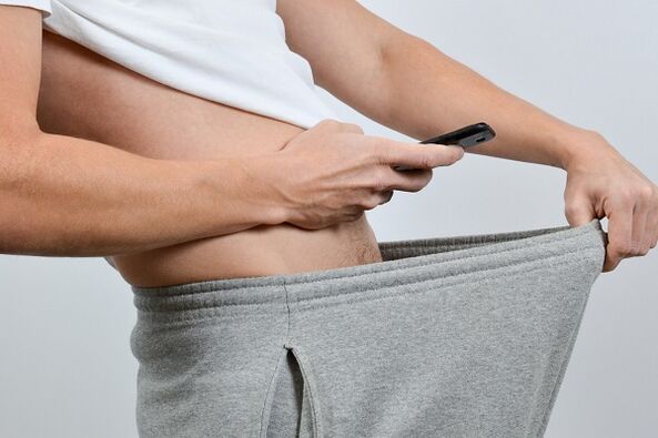 Ер адам шалбарын үлкейтілген пениске қарайды